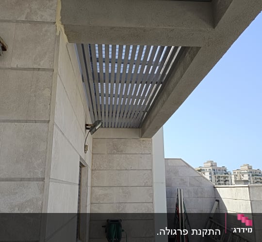 פרגולה מאלומיניום מותקנת על קיר חיצוני